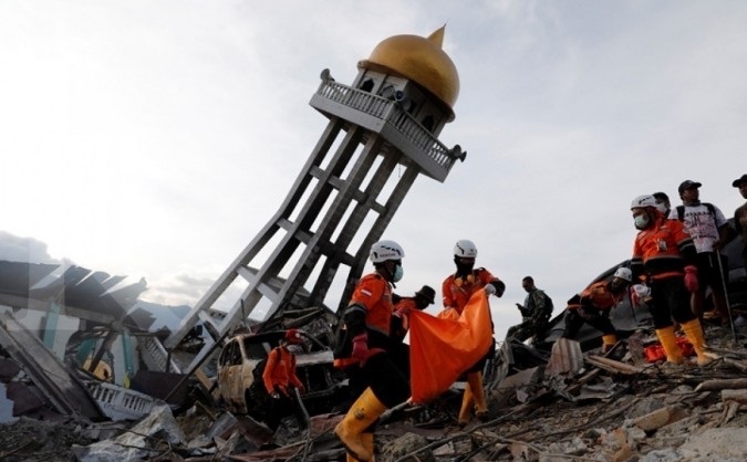 Rescue members carry a dead body from last week's earthquake in the Balaroa neighbourhood in Palu