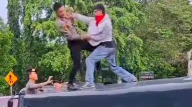 Salah satu aparat dan pendemo adu ketangkasan di atas truk Polisi. (Foto Istimewa)